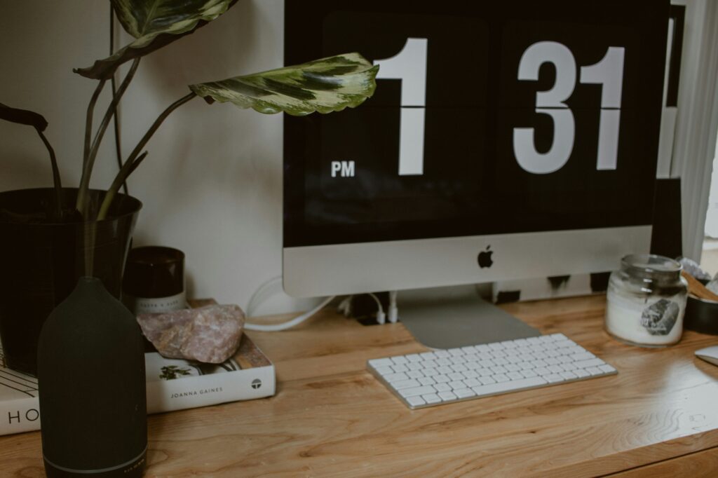 Clean minimalist workspace with iMac displaying clock on wooden desk - marketing professional's workspace
